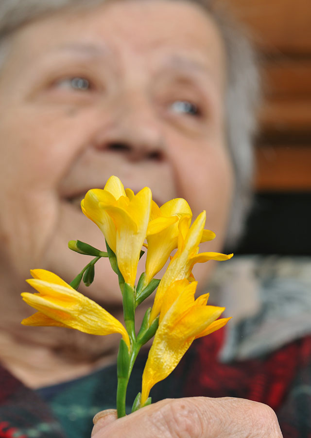 Elderly Woman Holding Flower